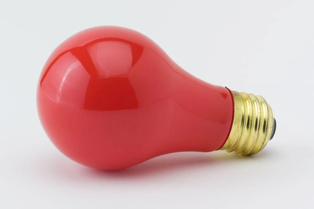 A red light bulb on a white background